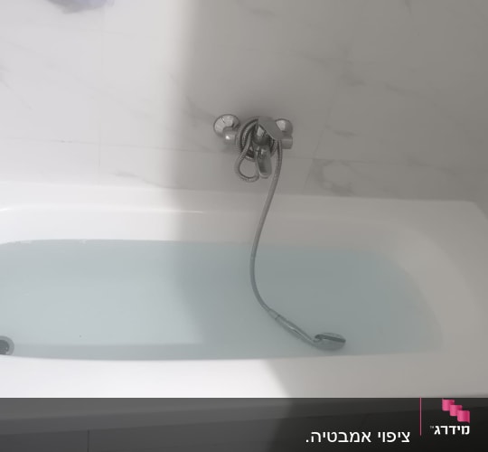אמבטיה עם חיפוי קירות ושפופרת מים